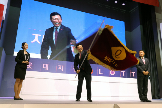 롯데지주는 12일 서울 잠실 시그니엘서울에서 출범식을 진행했다. 이날 행사에서 신동빈 롯데그룹 회장(가운데)이 롯데지주 사기 전달 세리모니를 하고 있다. <롯데그룹 제공>